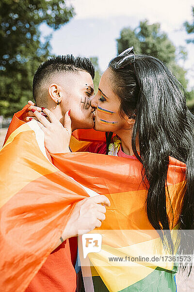 Junges lesbisches Paar küsst sich im Park