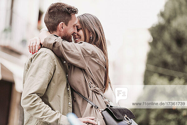 Frau lächelt  während sie ihren Freund umarmt