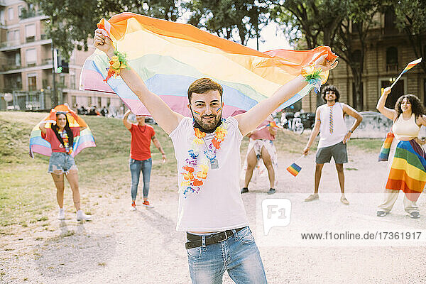 Young man with flag in pride event at park