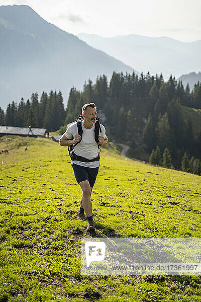 Male backpacker hiking on mountain during sunny day