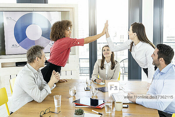 Weibliche Kollegen geben sich bei einem Treffen im Büro die Hand