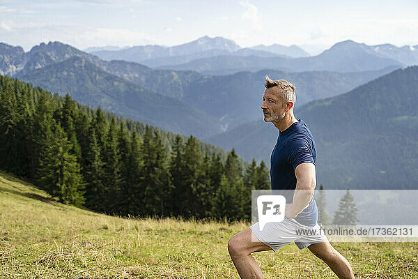 Man with hand on hip stretching while exercising