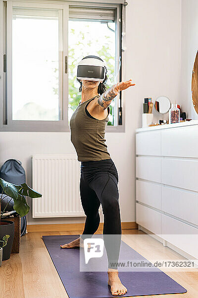 Woman using virtual reality headset while exercising at home