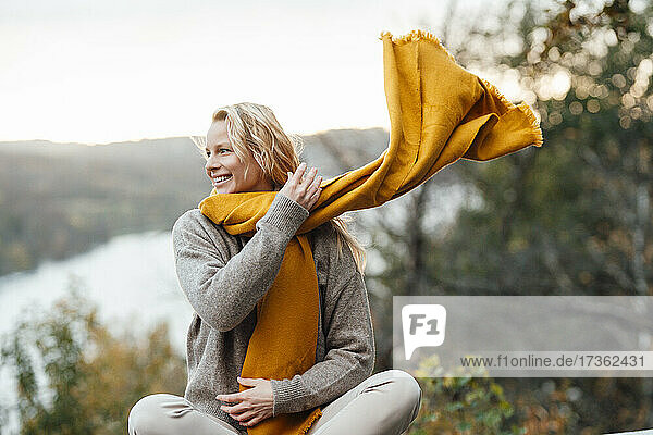 Lächelnde  wegschauende Frau mit Schal im Herbst