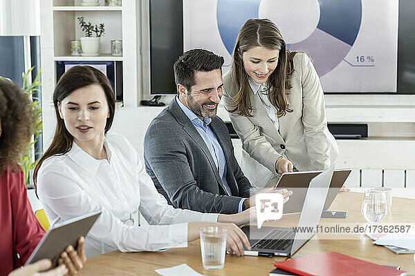 Professionelles Team bei der Arbeit mit einem digitalen Tablet während einer Besprechung im Büro
