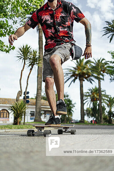 Man balancing while skateboarding on road