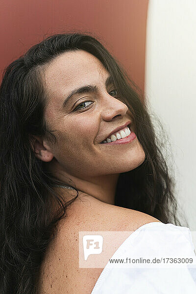 Lächelnde junge Frau mit langen schwarzen Haaren