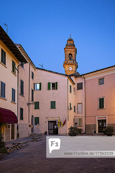Italien  Provinz Pisa  Pomarance  Piazza de Larderel in der Abenddämmerung mit dem Glockenturm der Kirche von San Giovanni Battista im Hintergrund