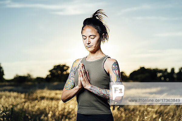 Frau meditiert beim Yoga auf dem Lande
