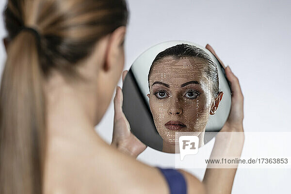 Weiblicher Roboter betrachtet Spiegelbild auf weißem Hintergrund