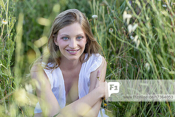 Lächelnde junge Frau auf einem landwirtschaftlichen Feld