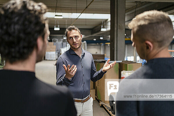 Businessman explaining male colleagues at industry