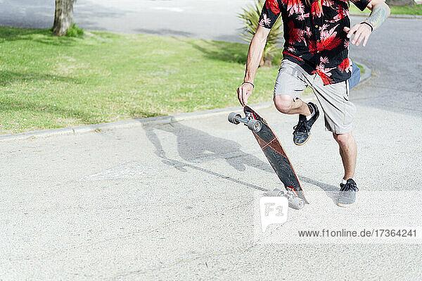 Junger Mann mit Skateboard auf der Straße