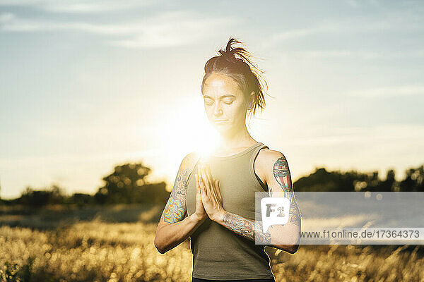 Mittlere erwachsene Frau meditiert beim Yoga auf dem Lande