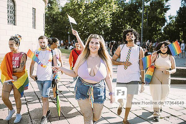 Lächelnde männliche und weibliche Aktivisten  die während einer Pride-Veranstaltung protestieren