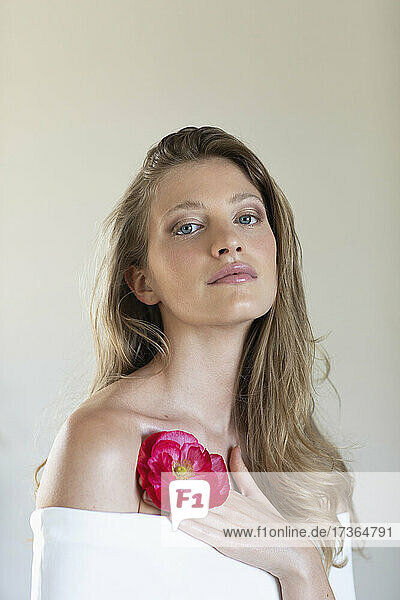 Beautiful young woman with red poppy flower in studio