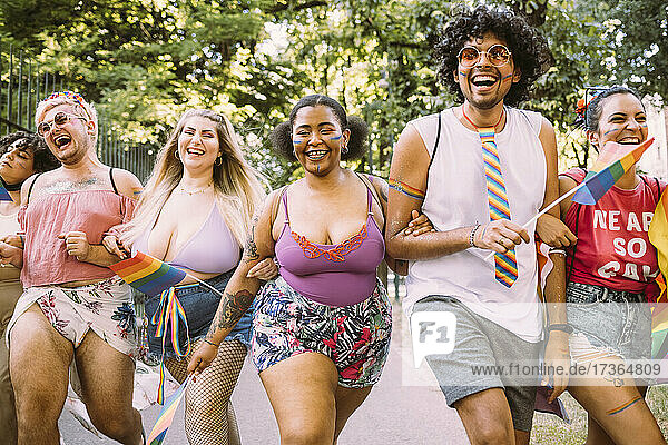Glückliche männliche und weibliche Demonstranten halten sich bei der Pride-Veranstaltung an den Händen