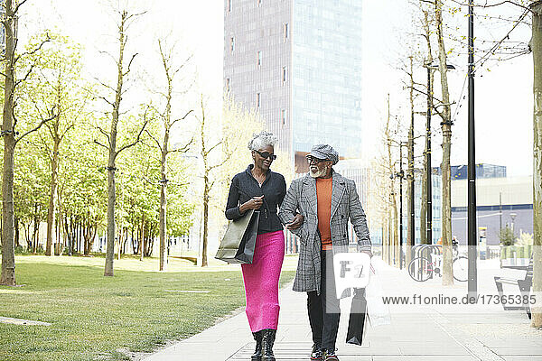 Ehepaar mit Einkaufstüten auf dem Fußweg in der Stadt