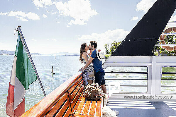 Paar küsst sich im Fährboot stehend