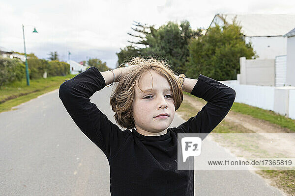 Achtjähriger Junge  Hände auf dem Kopf  Porträt