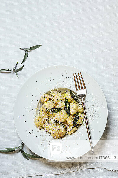 Teller mit verzehrfertigen italienischen Gnocchi-Knödeln mit geriebenem Parmesan