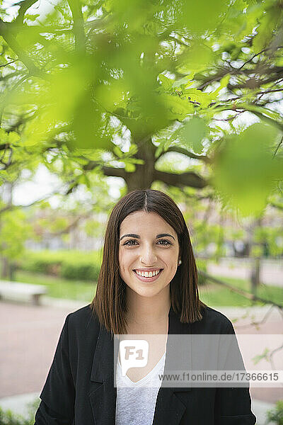 Lächelnde schöne junge Frau im Park