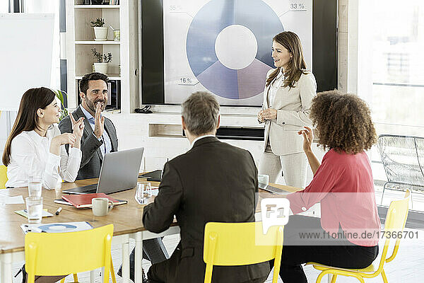 Female professional attending meeting with colleague at office