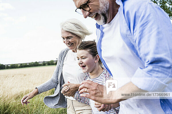 Fröhliche Enkelin und Großeltern verbringen gemeinsam ihre Freizeit