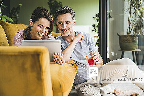 Couple using digital tablet while sitting at home