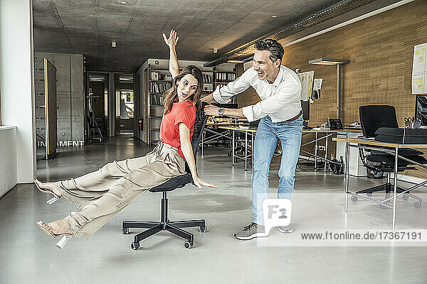 Male and female colleague having fun while playing in office