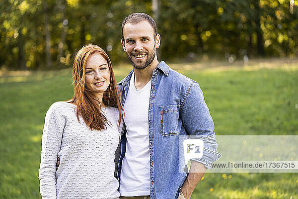 Portrait of smiling young couple enjoying a stroll in a park