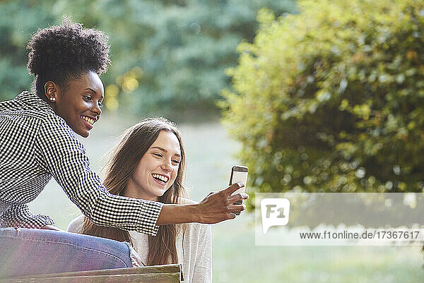 Lächelnde junge Freunde machen ein Selfie mit ihrem Smartphone