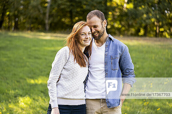 Portrait of smiling young couple enjoying a stroll in a park