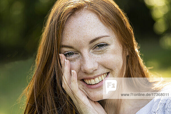 Porträt einer lächelnden jungen Frau im Park