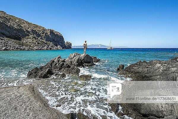 Junge Frau in Badesachen am Strand auf Gyali  hinten Segelboot  Dodekanes  Griechenland  Europa