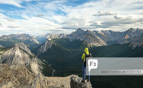 Wanderer steht auf einem Felsen  Berglandschaft mit Flusstal und Gipfeln  Gipfel mit orangene Sulphurablagerungen  Overturn Mountain  Panoramablick  Nikassin Range  Sulphur Skyline  bei Miette Hotsprings  Jasper Nationalpark  Alberta  Kanada  Nordamerika