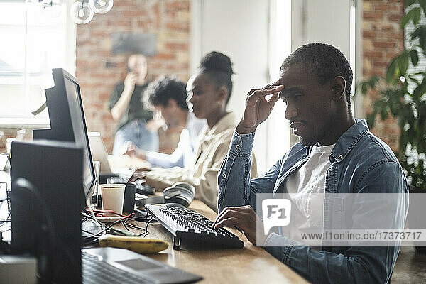 Multi-ethnic male and female hackers working at office