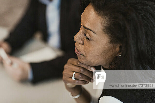 High angle view of businesswoman with hand on chin in corporate training