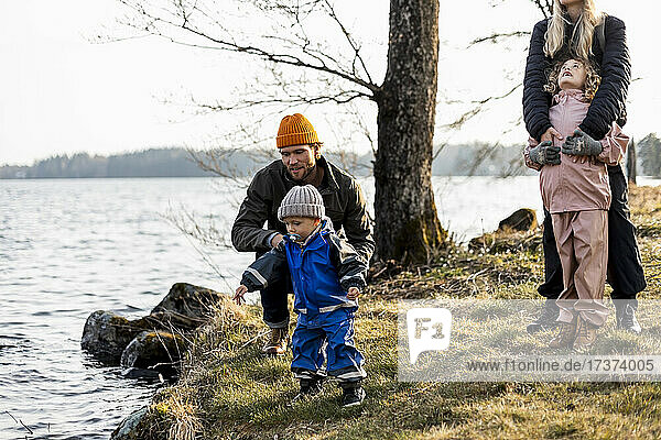 Man and woman with son and daughter by lake at park