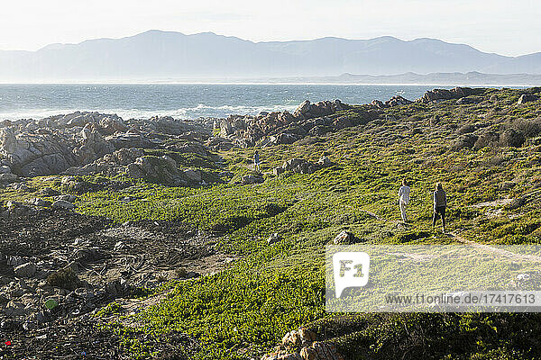 Frau und zwei Kinder wandern auf einem Küstenpfad an der Atlantikküste
