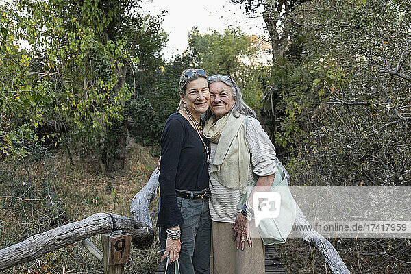 Eine erwachsene Frau und ihre Mutter auf einem Weg durch die Bäume in einem Safaricamp