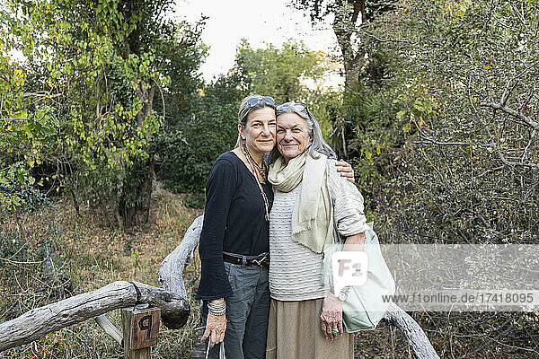 Eine erwachsene Frau und ihre Mutter auf einem Weg durch die Bäume in einem Safaricamp