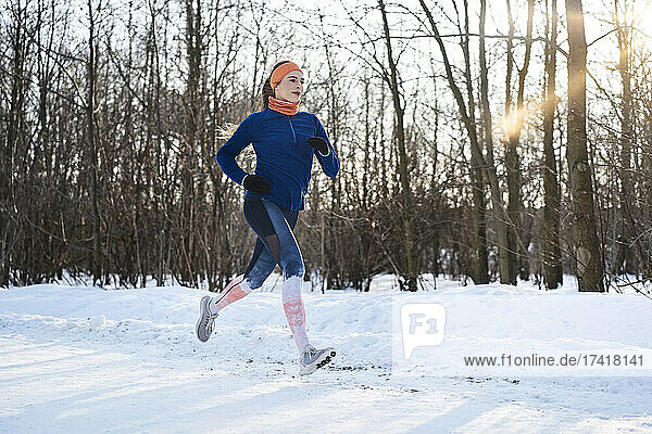 Young woman jogging on snow