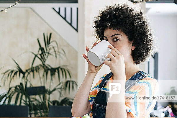 Junge Frau trinkt zu Hause Kaffee