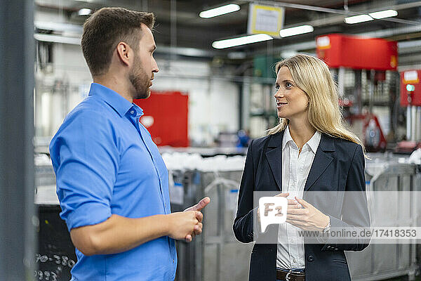 Businessman discussing with female manager at factory