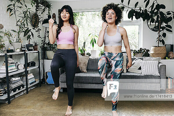 Female friends practicing zumba while exercising in living room