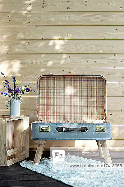Suitcase chair in front of wooden wall