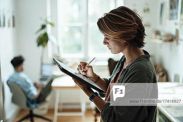 Businesswoman using graphic tablet while working at home
