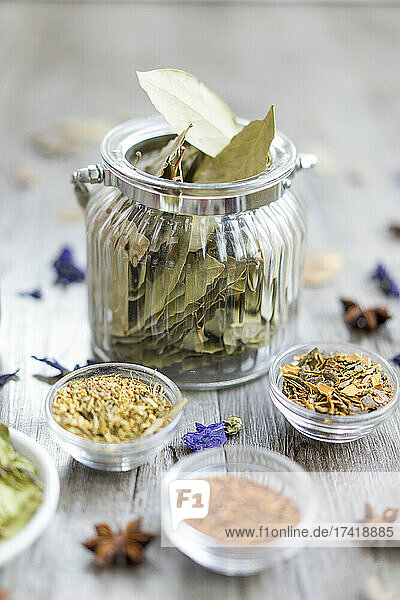 Arrangement of bay leafs in jar and other spices in bowl