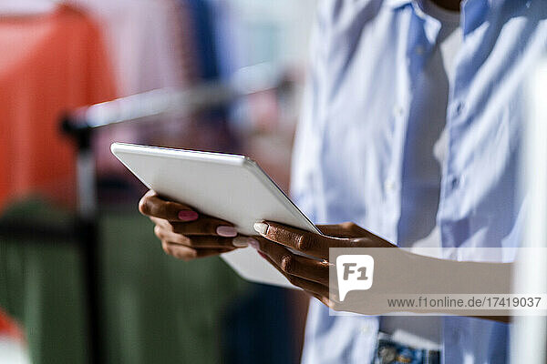 Female entrepreneur holding digital tablet at studio